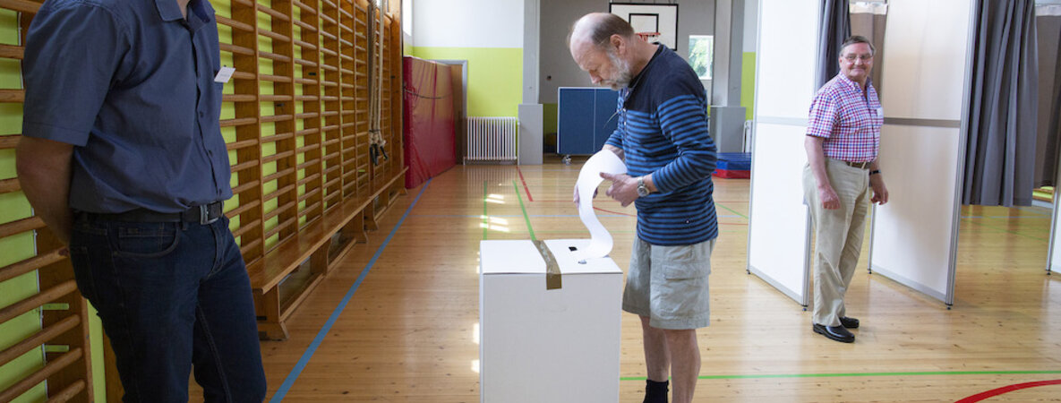 Jens Knudsen steckt seinen Wahlzettel in den Schlitz der Wahlurne.