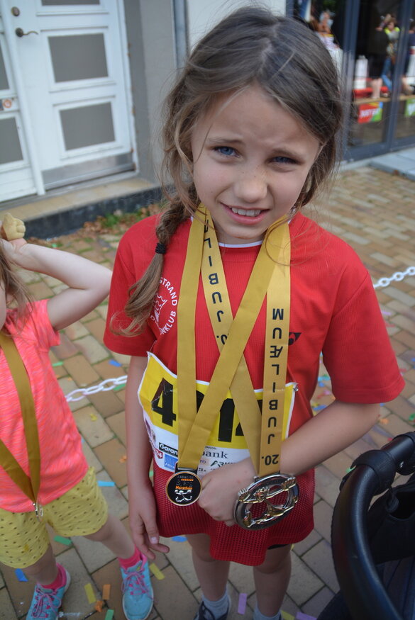 Die achtjährige Alva Jacobsen hält stolz ihre kleine Medaillensammlung in die Kamera