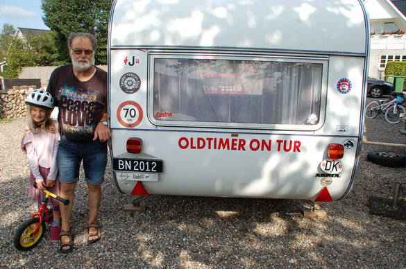 Henrik Holm und Enkelin vor dem Wohnwagen, in dem bei Oldtimertreffen übernachtet  wird.
