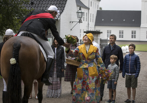 Stefan Kleinschmidt, Vizebürgermeister von Sonderburg, überreicht Königin Margerethe vorm Schloss Gravenstein vom Pferd aus einen Blumenstrauß.