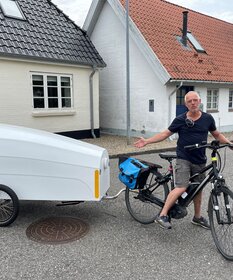 Bootsbauer Jochen Dunker mit seinem Transport- und Schlafanhänger, den er aus Holz in traditioneller Klinkerbauweise gefertigt hat.