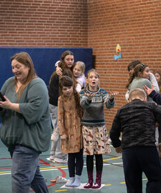 Kinder im Alter von acht bis elf stehen in einer Turnhalle jeweils zu zweit auf den Zeitungen. Noch gibt es eine große Fläche, auf der sie stehen können. Pro Runde wird die Zeitung nämlich immer kleiner.